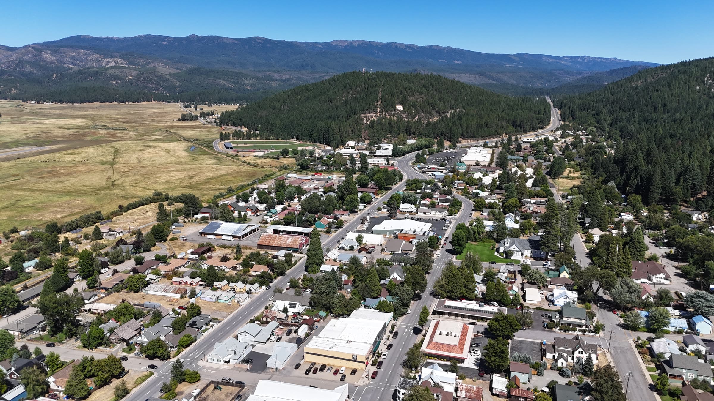 Oblique drone overview of a small-town street network and surrounding valley context